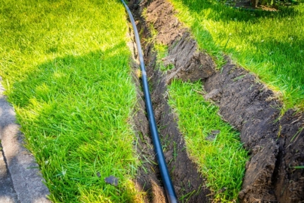 Ditch in grassy lawn with electrical conduit