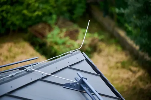 Lightning protection rod and snow guards on a roof corner