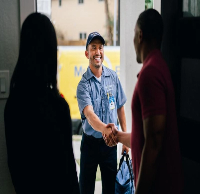 Mr. Electric technician shaking hands with a homeowner at the doorway to their home before performing an electric service call. 