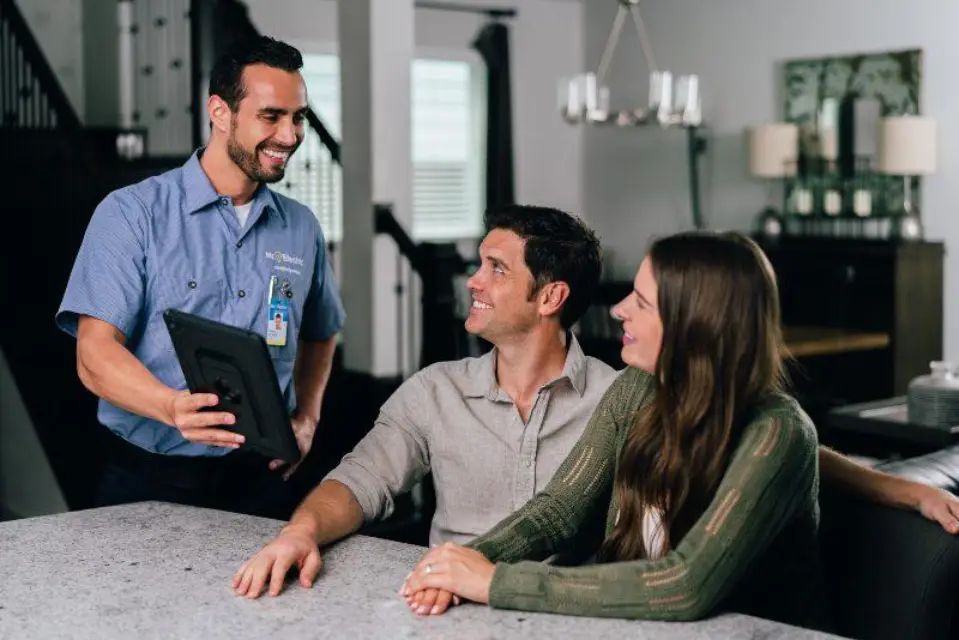 Electrician showing a tablet to a family.