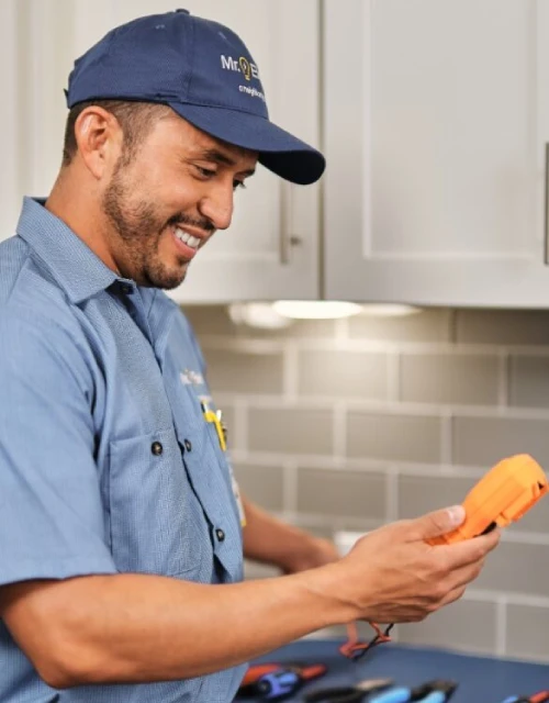 Mr. Electric professional holding tools in kitchen.