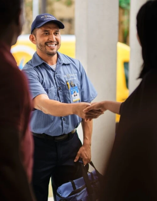 Mr. Electric technician shaking hands with customer.