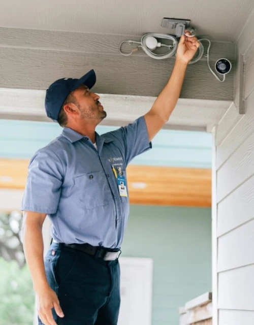 MRE tech fixing outdoor security camera.