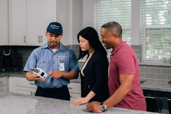 Mr. Electric electrician showing an electrical panel to customers.