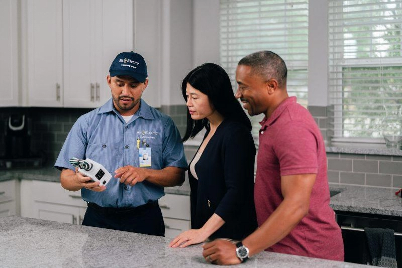 Mr. Electric electrician explaining electrical code updates to a couple.