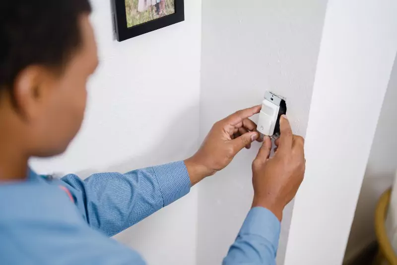 Mr. Electric electrician is installing a light sensor.