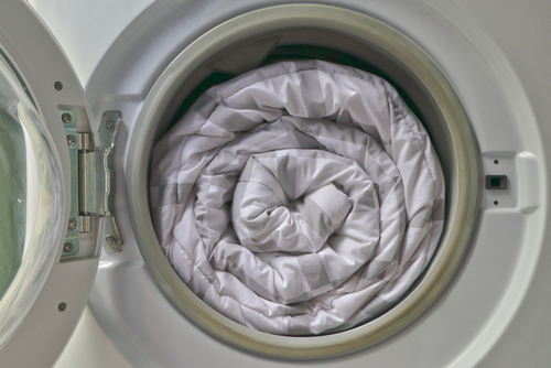 Neatly rolled electric blanket inside front-load washing machine.