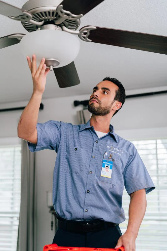 Mr. Electric electrician performing a ceiling fan installation.